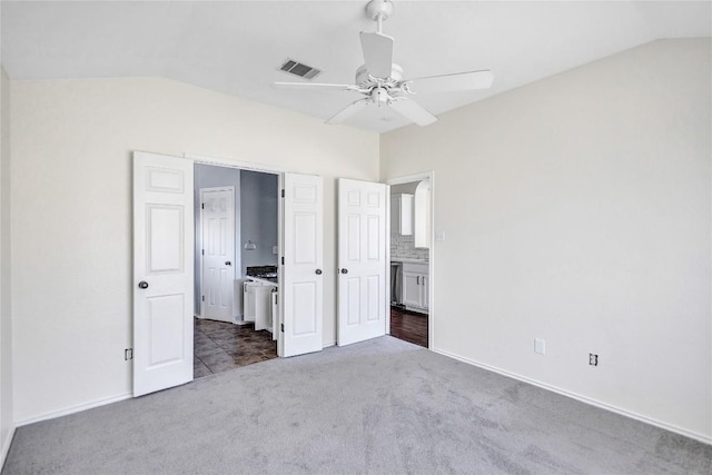 17616 Strontian Pass, Pflugerville, TX 78660 - unfurnished bedroom featuring dark carpet, lofted ceiling, ensuite bathroom, baseboards, and a ceiling fan