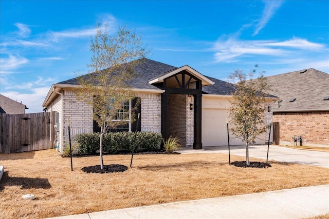 single story home featuring brick siding, fence, roof with shingles, a garage, and driveway