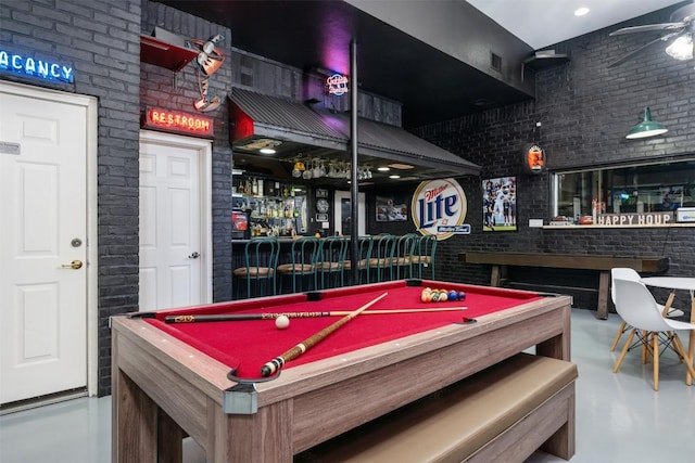 game room with brick wall, billiards table, a dry bar, and finished concrete flooring