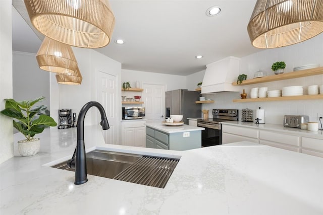 kitchen featuring stainless steel appliances, white cabinetry, a sink, and open shelves