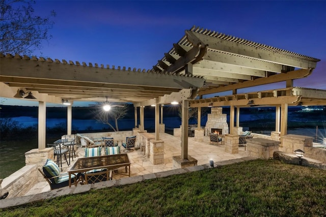 view of patio with an outdoor stone fireplace and a pergola