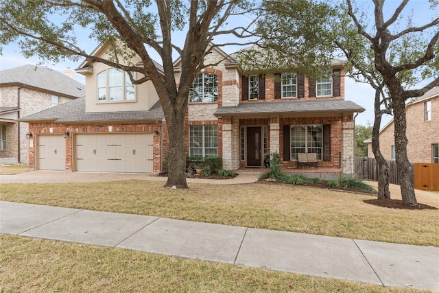 traditional home featuring brick siding, roof with shingles, concrete driveway, a front yard, and fence