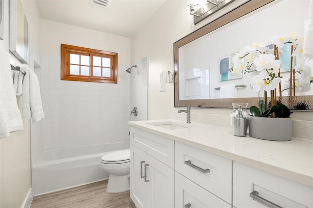 full bath featuring visible vents, toilet, wood finished floors, vanity, and shower / bathing tub combination