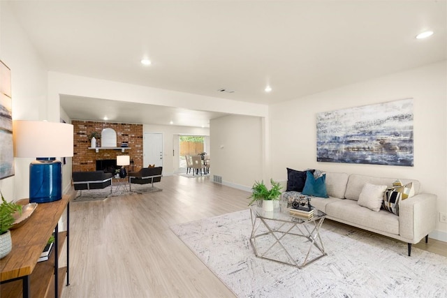 living room featuring baseboards, a fireplace, wood finished floors, and recessed lighting