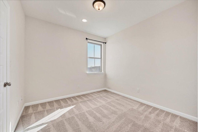 spare room with recessed lighting, baseboards, and light colored carpet