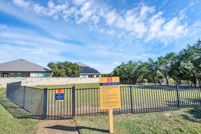 view of gate with a lawn and fence