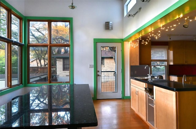 4708 Shoalwood Ave, Austin, TX 78756 - kitchen with plenty of natural light, dark countertops, wood finished floors, and a towering ceiling