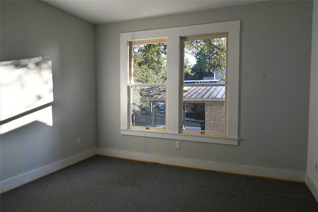 carpeted empty room featuring baseboards