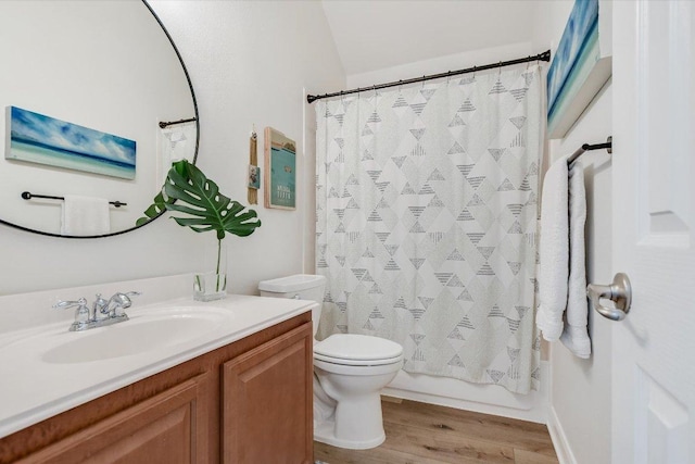 bathroom with toilet, shower / bath combo with shower curtain, wood finished floors, and vanity