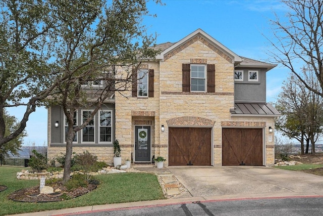 traditional-style home with a garage, fence, stone siding, driveway, and a standing seam roof