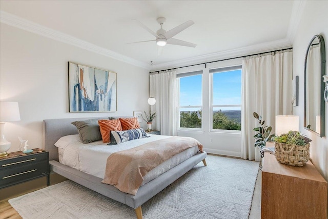 bedroom with light wood-style floors, ceiling fan, and ornamental molding