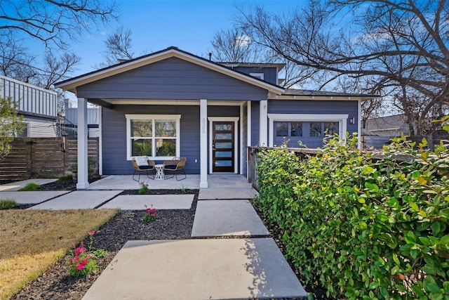 view of front of house featuring fence and a porch