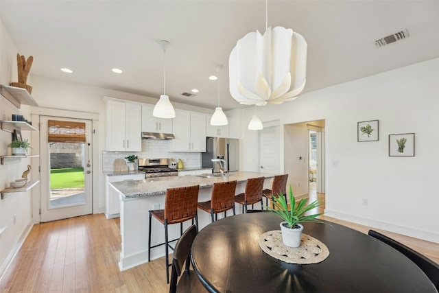 dining room featuring recessed lighting, baseboards, visible vents, and light wood finished floors