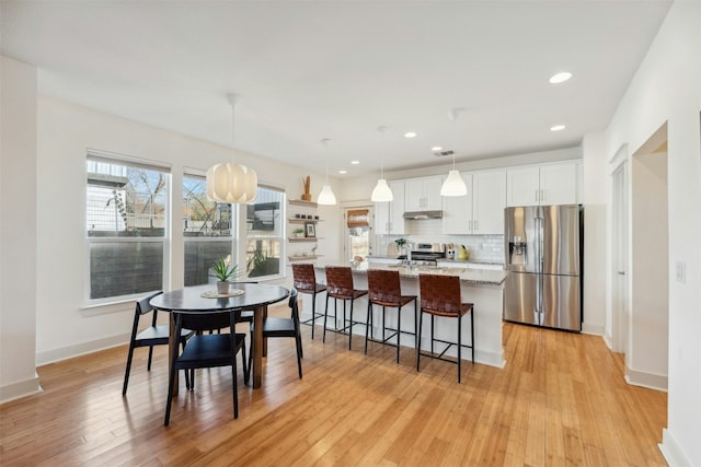 dining room featuring recessed lighting, baseboards, and light wood finished floors