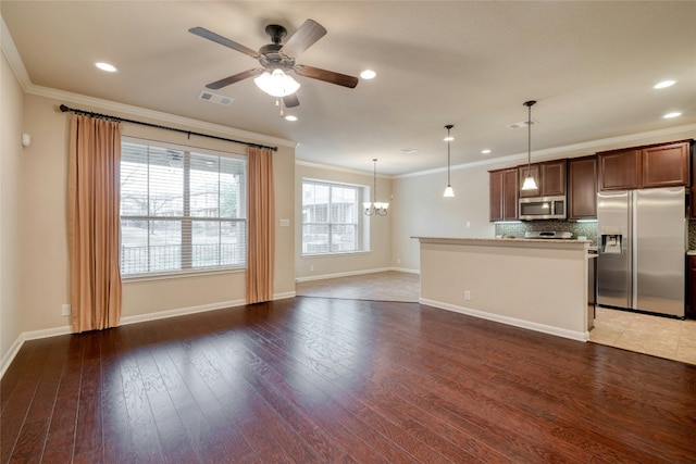 kitchen with visible vents, backsplash, appliances with stainless steel finishes, light wood-style floors, and ornamental molding