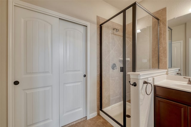 full bathroom featuring a shower stall, vanity, and tile patterned floors