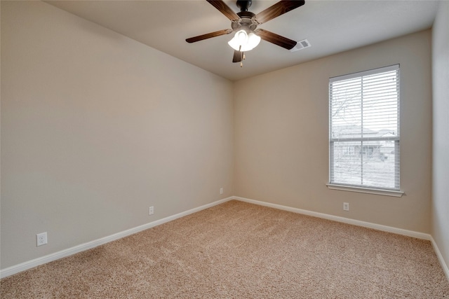 spare room featuring carpet, visible vents, ceiling fan, and baseboards