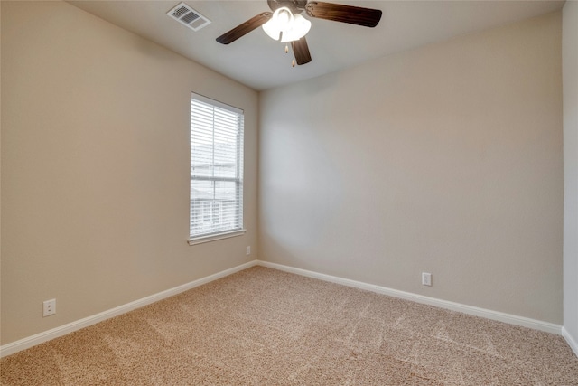 carpeted spare room with baseboards, visible vents, and a ceiling fan