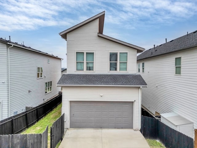 exterior space featuring driveway, a shingled roof, an attached garage, and fence