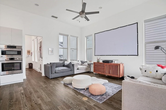 home theater room featuring ceiling fan, visible vents, and dark wood-style flooring