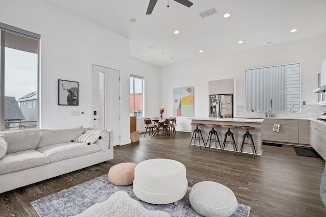 living area with dark wood-style floors, visible vents, a ceiling fan, and recessed lighting