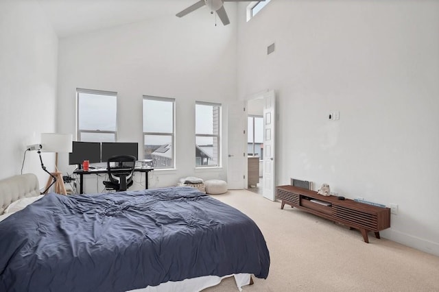 carpeted bedroom featuring a towering ceiling, ceiling fan, visible vents, and connected bathroom