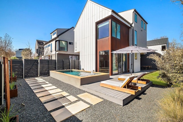 back of property featuring a gate, fence, and board and batten siding