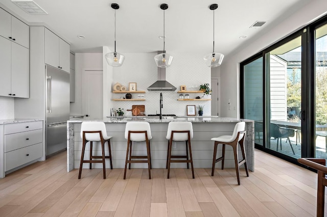 1712 Nash Ave Unit A, Austin, TX 78704 - kitchen featuring built in fridge, open shelves, light wood-style floors, a breakfast bar, and recessed lighting