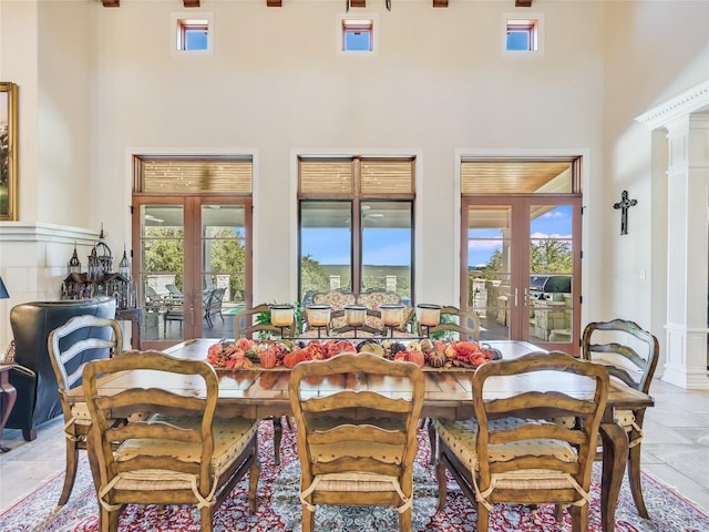 dining area with a high ceiling, a wealth of natural light, and french doors
