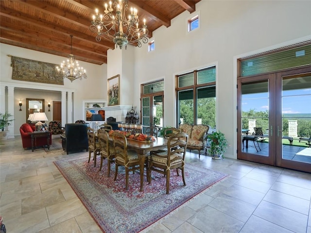 dining area with a chandelier, french doors, a towering ceiling, wooden ceiling, and beam ceiling