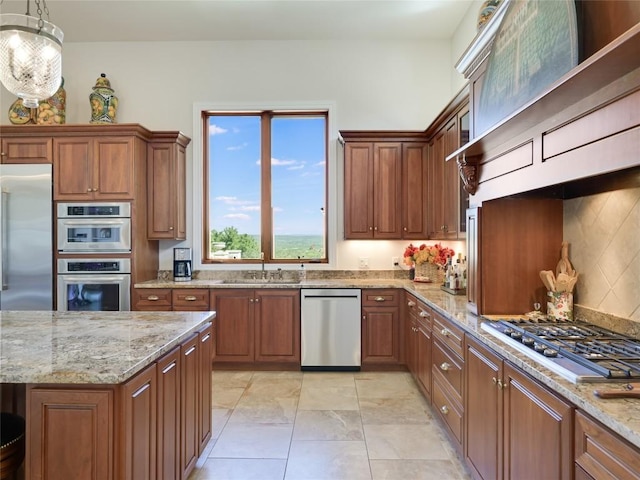 kitchen featuring decorative backsplash, a sink, brown cabinets, and appliances with stainless steel finishes