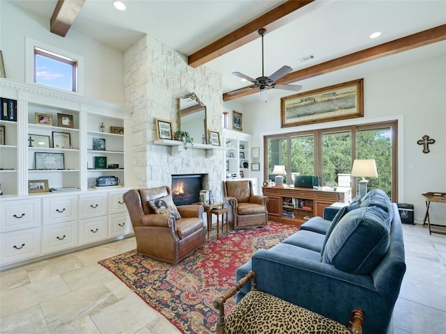 living area with a towering ceiling, visible vents, a ceiling fan, beam ceiling, and a fireplace