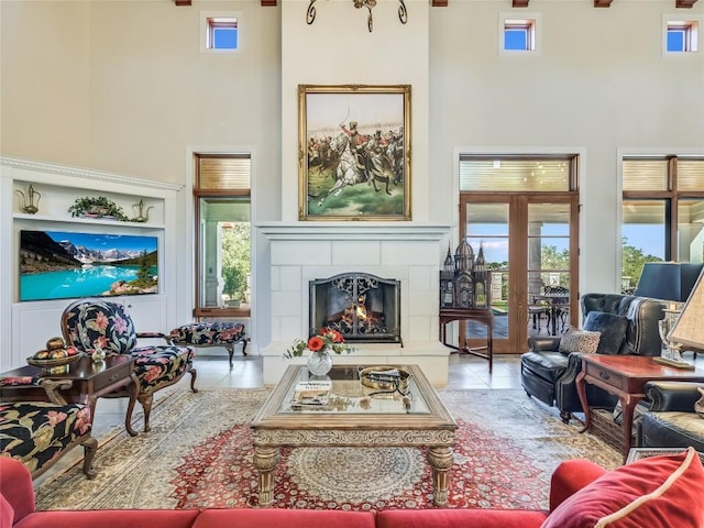 living room featuring tile patterned floors, a tile fireplace, a high ceiling, and plenty of natural light