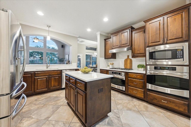 kitchen featuring a center island, stainless steel appliances, light countertops, under cabinet range hood, and a sink