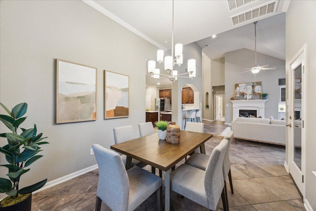 dining room with baseboards, visible vents, arched walkways, a fireplace, and high vaulted ceiling