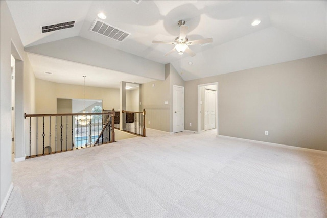 unfurnished room with baseboards, visible vents, vaulted ceiling, and light colored carpet