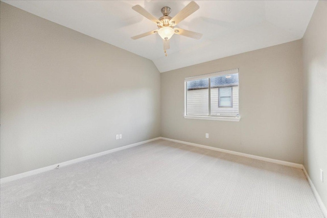 unfurnished room with lofted ceiling, light colored carpet, ceiling fan, and baseboards