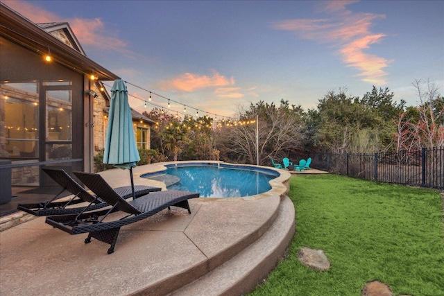 pool at dusk featuring a fenced in pool, a yard, fence, and a patio