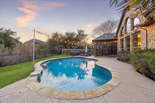 view of swimming pool with a fenced in pool, a lawn, a sunroom, a fenced backyard, and a patio area