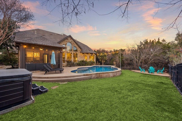 view of swimming pool with a patio, a lawn, fence, and a hot tub