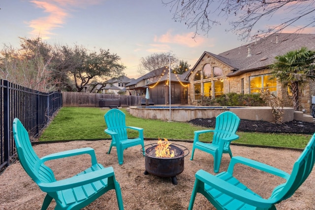 exterior space with a pool, an outdoor fire pit, a fenced backyard, and a lawn