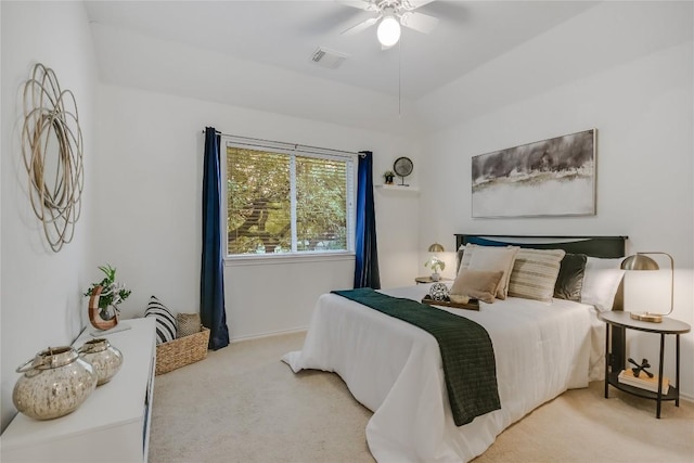 bedroom featuring a raised ceiling, carpet flooring, visible vents, and a ceiling fan