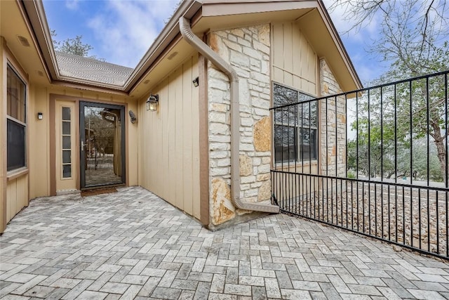 property entrance with stone siding and a gate