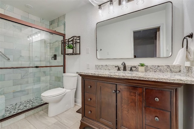 bathroom featuring toilet, a shower stall, and vanity