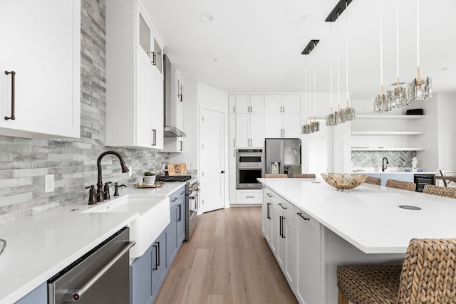 1105 Oak Hurst Rd, Austin, TX 78734 - kitchen with stainless steel appliances, beverage cooler, light wood-type flooring, white cabinets, and a breakfast bar area