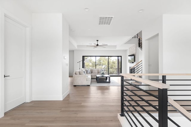 1105 Oak Hurst Rd, Austin, TX 78734 - hallway with light wood-style flooring, a raised ceiling, recessed lighting, and an upstairs landing
