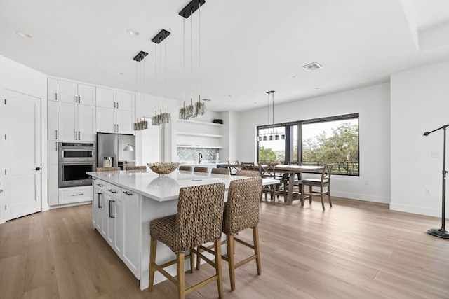1105 Oak Hurst Rd, Austin, TX 78734 - kitchen featuring stainless steel appliances, light wood-style flooring, open shelves, white cabinets, and recessed lighting