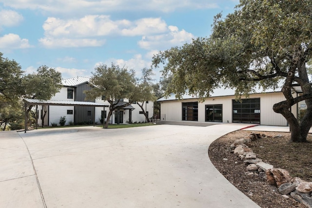 modern inspired farmhouse with a garage, metal roof, and driveway