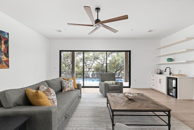 1105 Oak Hurst Rd, Austin, TX 78734 - living room featuring wine cooler, wet bar, light wood finished floors, and a ceiling fan