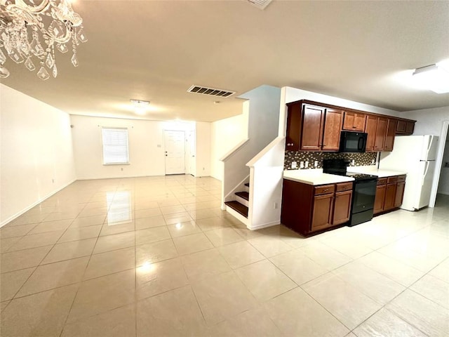 kitchen featuring tasteful backsplash, light countertops, visible vents, open floor plan, and black appliances